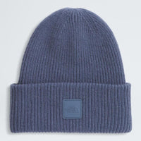 Blue knit beanie with a logo patch on a light gray background