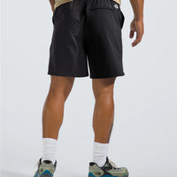 Person wearing black shorts with a brand logo on a light gray background