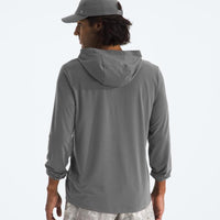 Person wearing a gray hoodie and cap on a light gray background