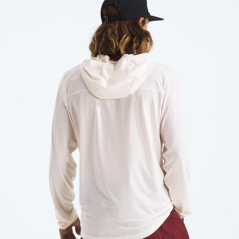 Person wearing a white hoodie and maroon pants with a black cap on a white background