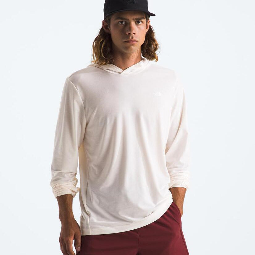 Man wearing a white hoodie and maroon pants on a plain background