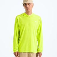 Person wearing a bright green hoodie with a logo on a white background