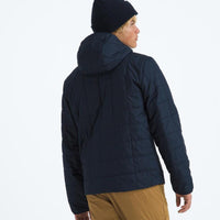 Person wearing a dark blue puffer jacket and black beanie on a white background