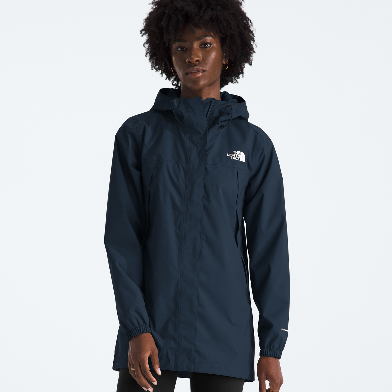 Person wearing a navy blue raincoat with a brand logo on a white background