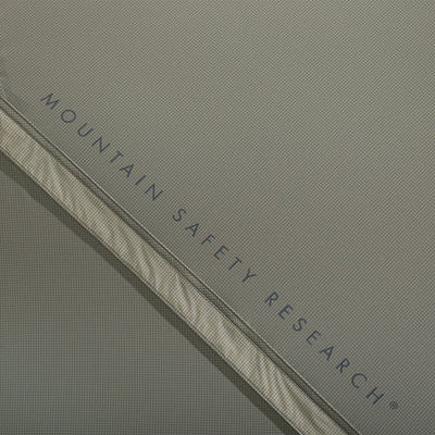 Close-up of a tent with 'Mountain Safety Research' branding on a gray background