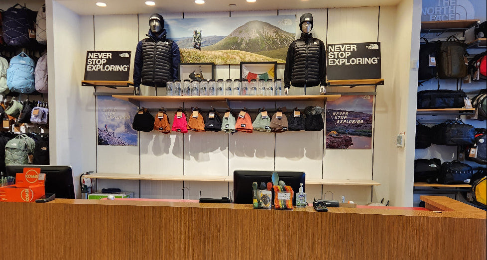 Store interior with shelves displaying backpacks and a reception desk.