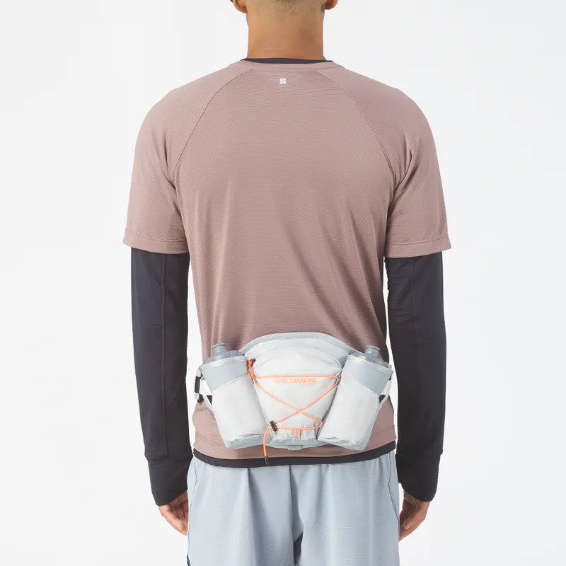 Person wearing a brown athletic shirt with a white waist bag on a white background