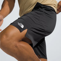 Person wearing black athletic shorts with The North Face logo on a light gray background