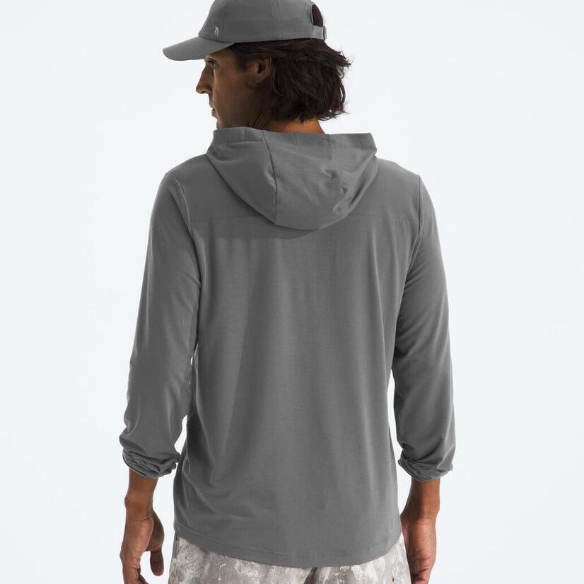 Person wearing a gray hoodie and cap on a light gray background