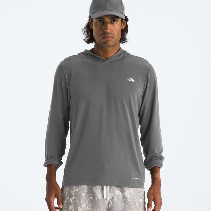 Man wearing a gray hoodie with a logo on a white background