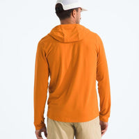 Man wearing an orange hoodie and beige pants on a white background
