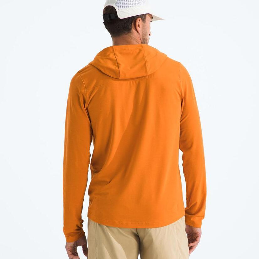 Man wearing an orange hoodie and beige pants on a white background