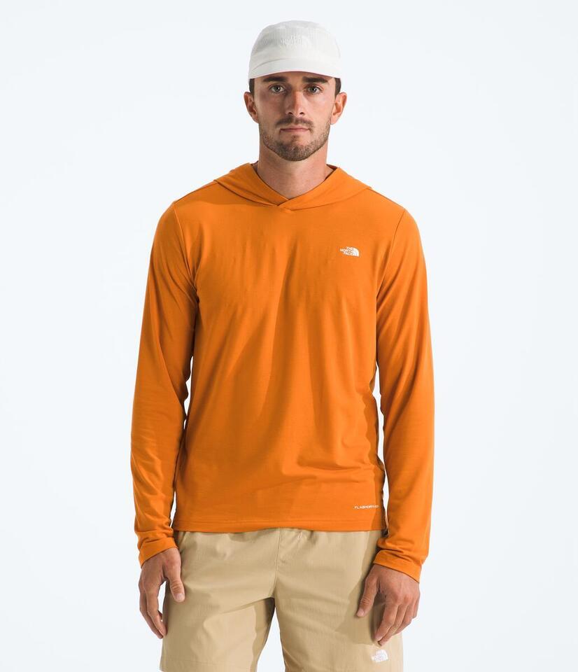 Man wearing an orange long-sleeve shirt with a logo on a white background