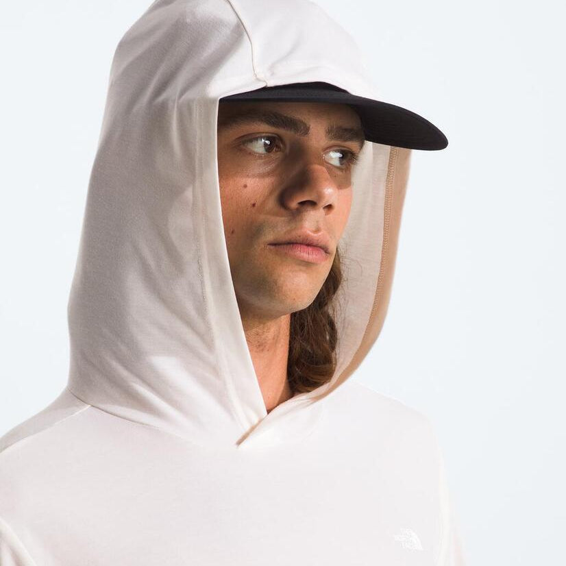 Person wearing a white sun hoodie with hood up against a light gray background