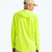 Person wearing a bright yellow long-sleeve shirt and beige cap on a white background