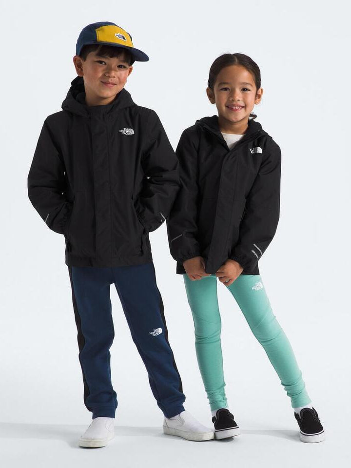 Two children wearing matching black hoodies with a brand logo on a white background