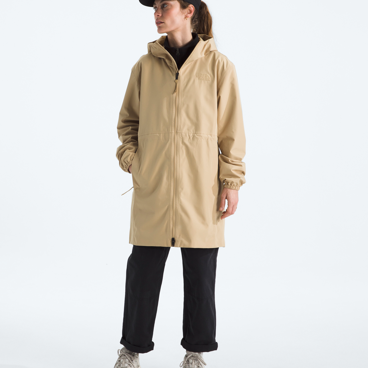 Person wearing a beige raincoat on a white background