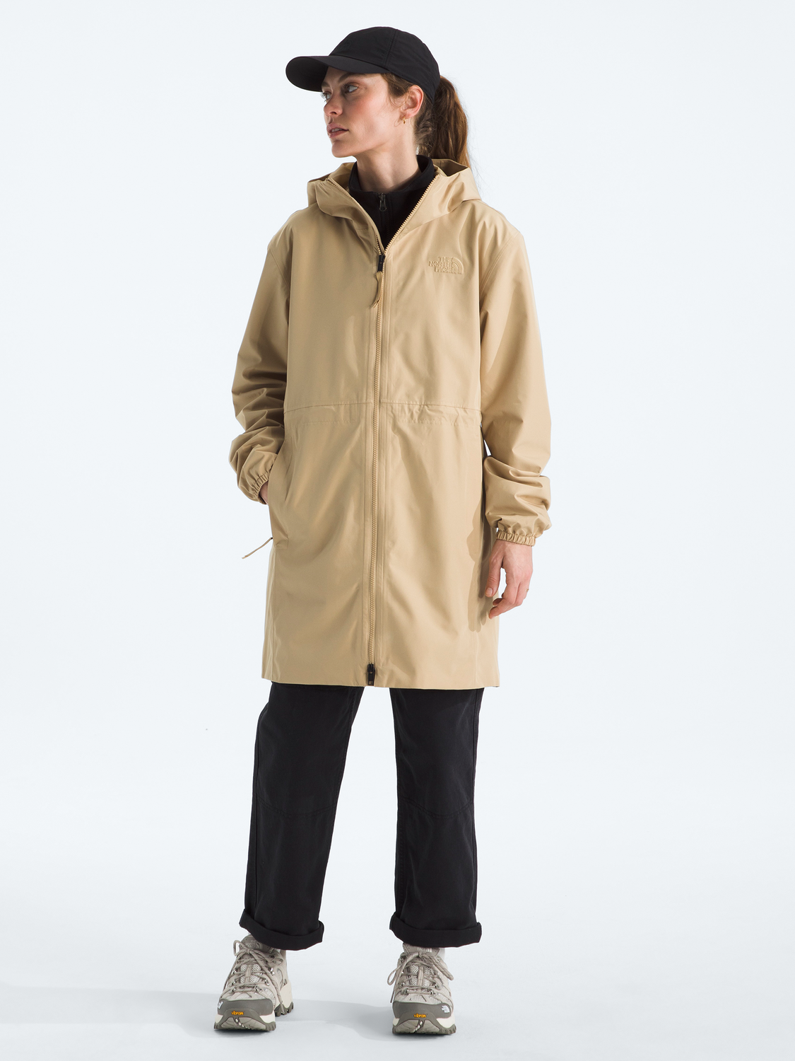 Person wearing a beige raincoat on a white background