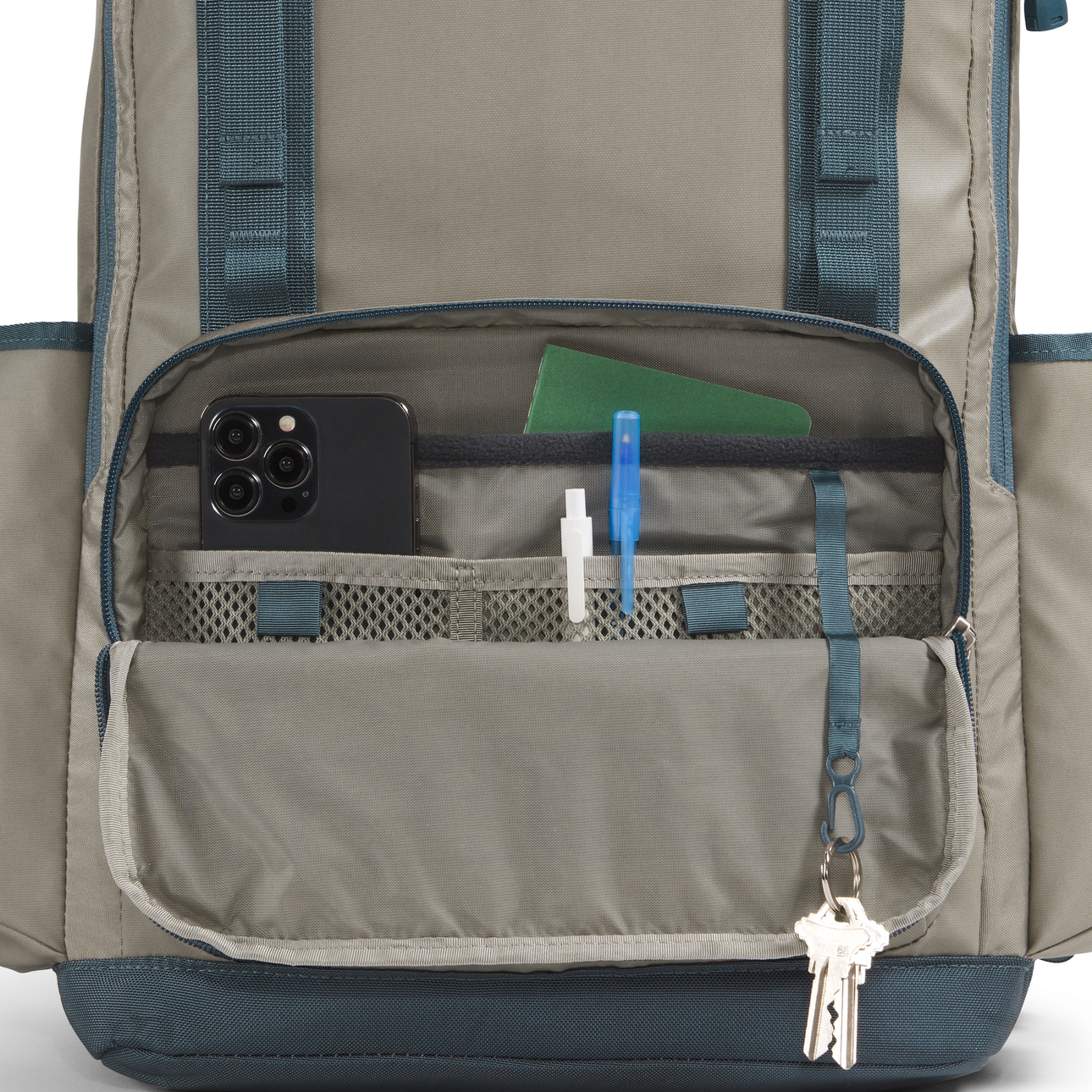 Close-up of a backpack with compartments and items inside on a white background