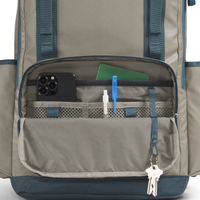 Close-up of a backpack with compartments and items inside on a white background